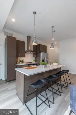 a kitchen with stainless steel appliances granite countertop a sink a stove a refrigerator and island