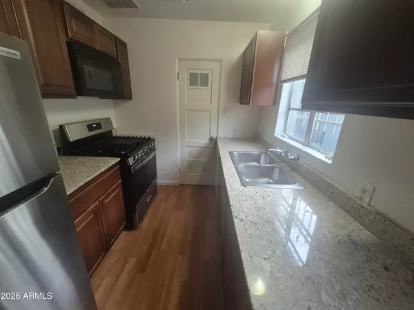 a kitchen with granite countertop a stove and a sink