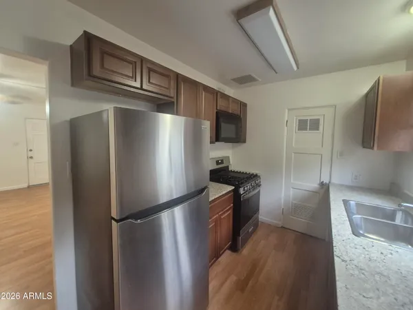 a metallic refrigerator freezer sitting in a kitchen