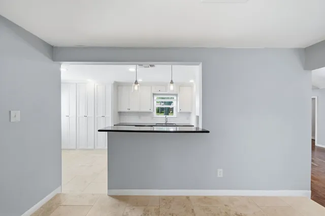 a kitchen with granite countertop a sink and cabinets