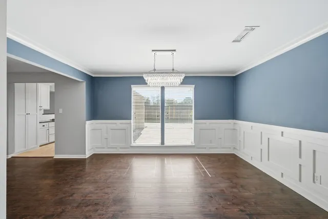 a view of empty room with wooden floor and window