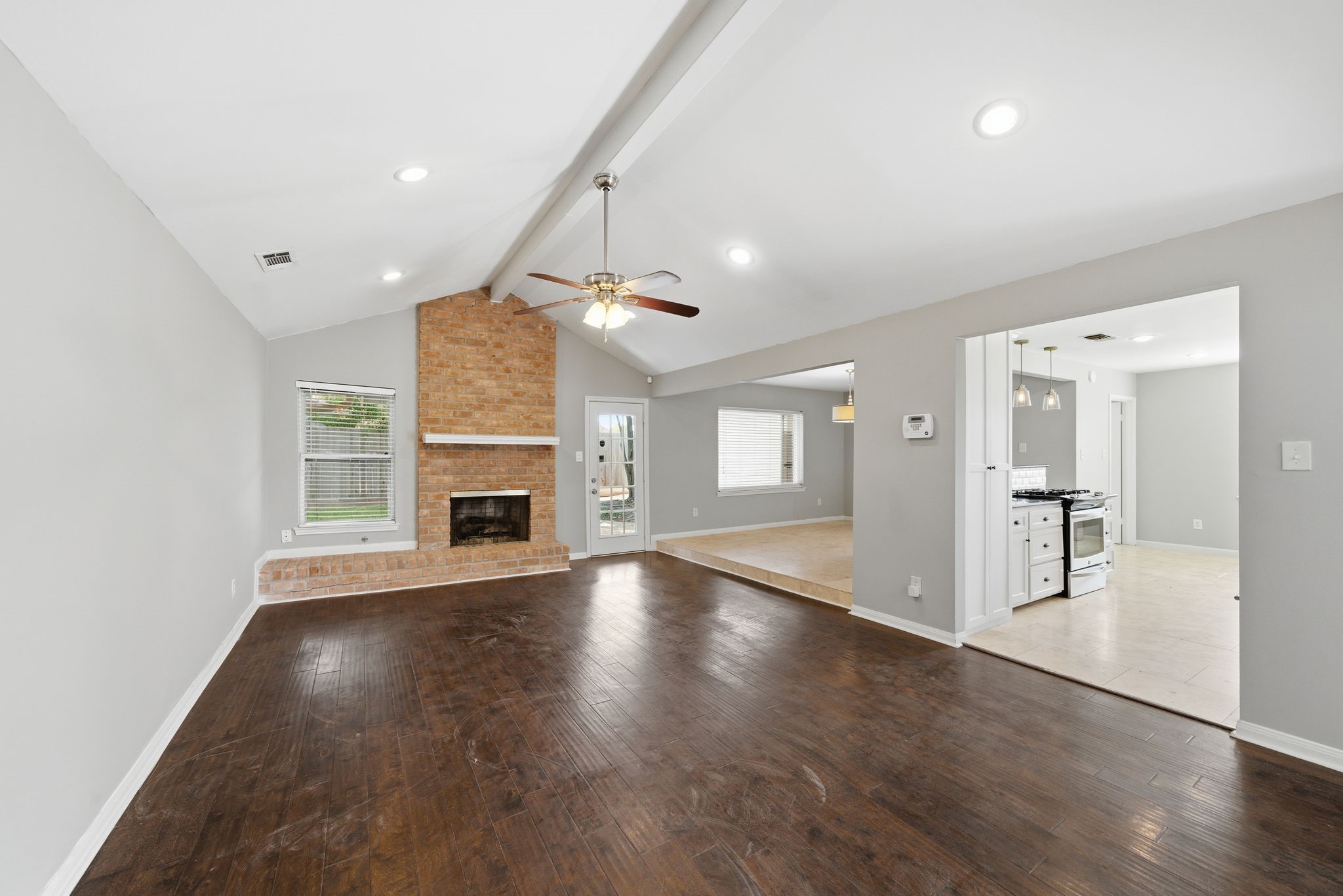 2502 Hollow Hook Road Houston, TX 77080 - Photo 8 of 35 an empty room with wooden floor fireplace and windows