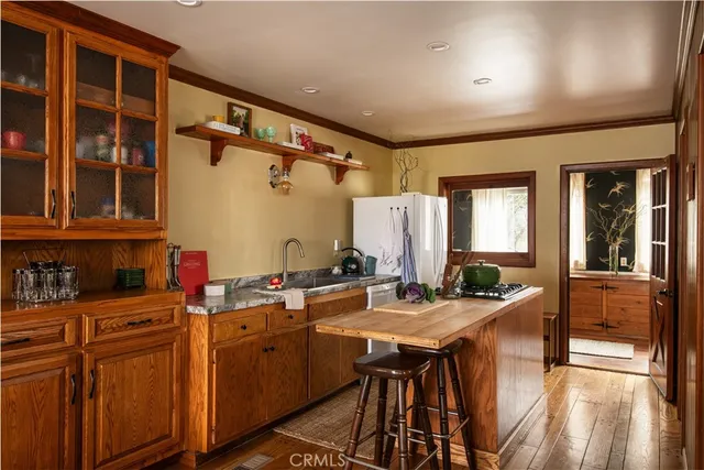 a kitchen with sink refrigerator dining table and chairs