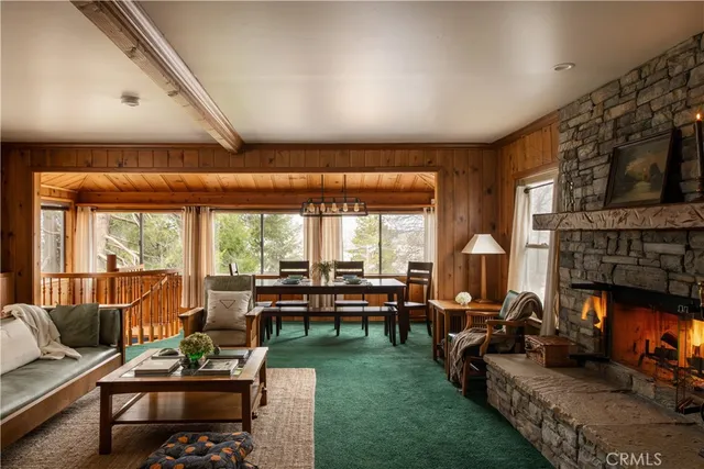 a living room with fireplace furniture and a large window