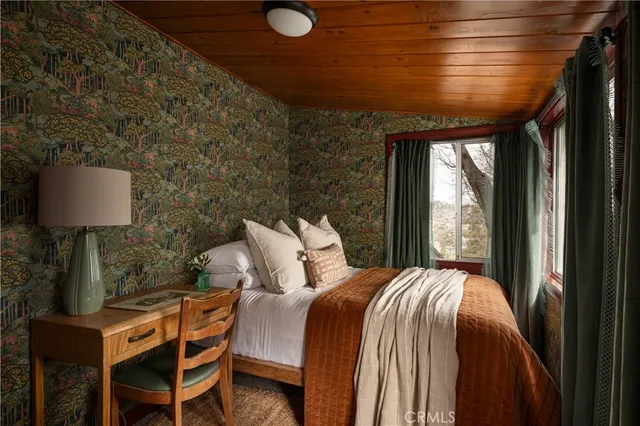 a bed sitting in a bedroom next to a window