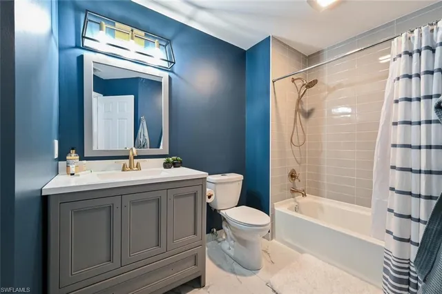 a bathroom with a sink and mirror with bathtub