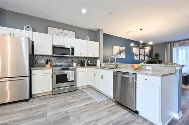 a kitchen with white cabinets stainless steel appliances and sink