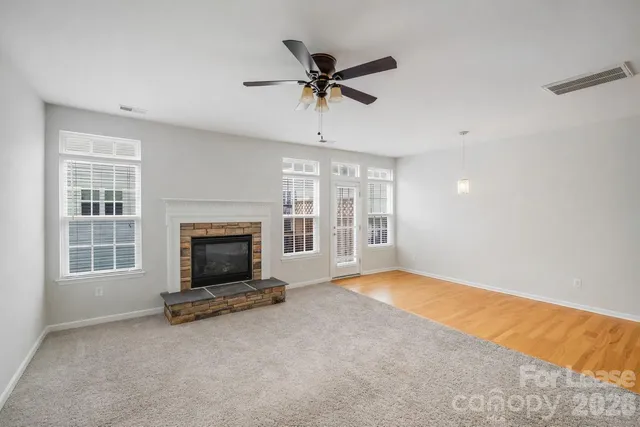 an empty room with fireplace and windows