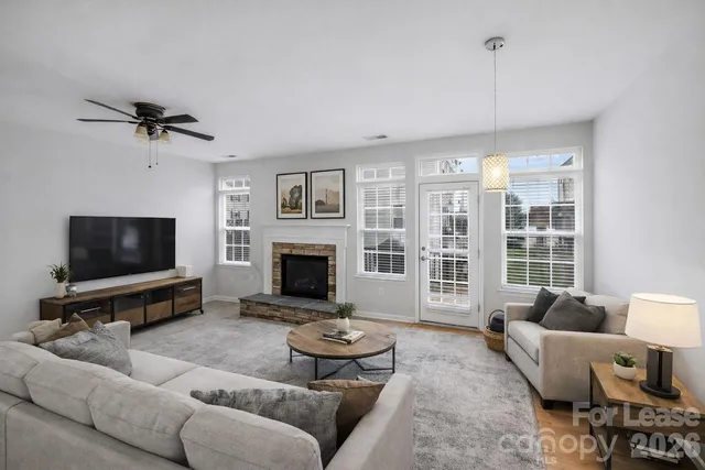 a living room with furniture a flat screen tv and a fireplace
