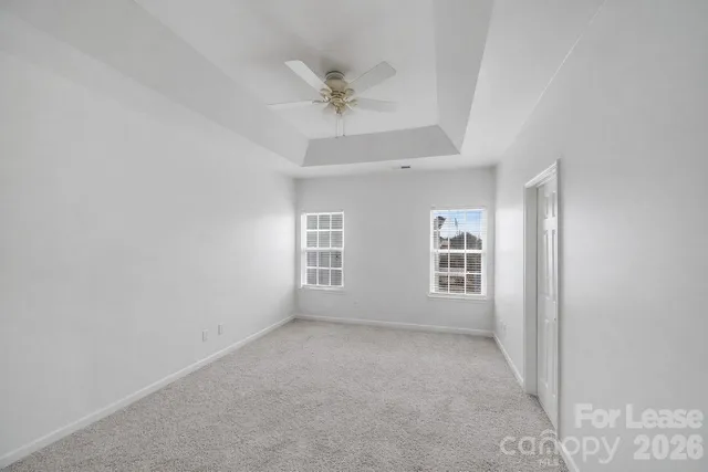a view of a big room with windows and chandelier fan