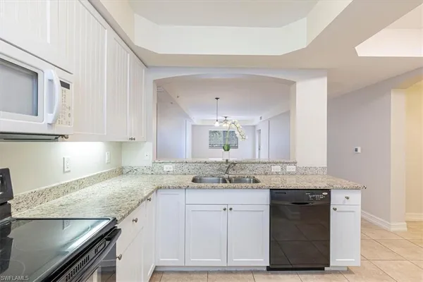 a kitchen with granite countertop a sink stainless steel appliances and cabinets