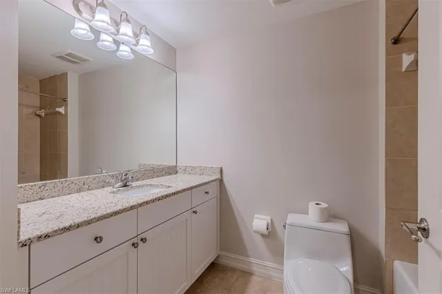 a bathroom with a granite countertop sink a toilet and a mirror