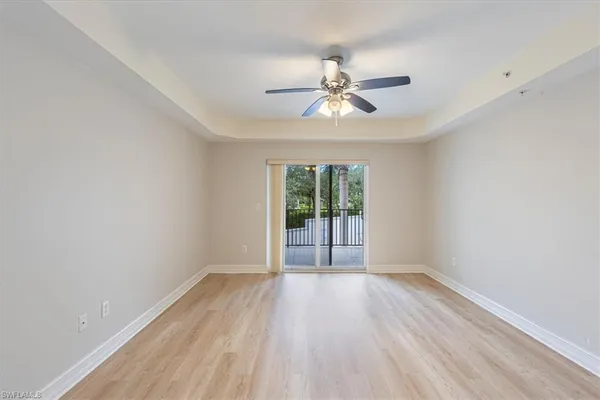 a view of wooden floor and a chandelier fan in a room