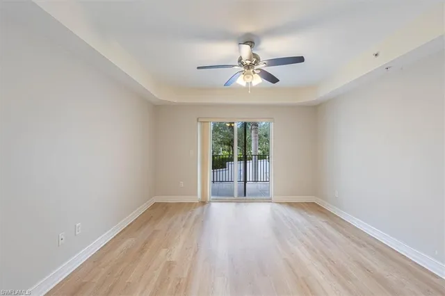 a view of wooden floor and a chandelier fan in a room
