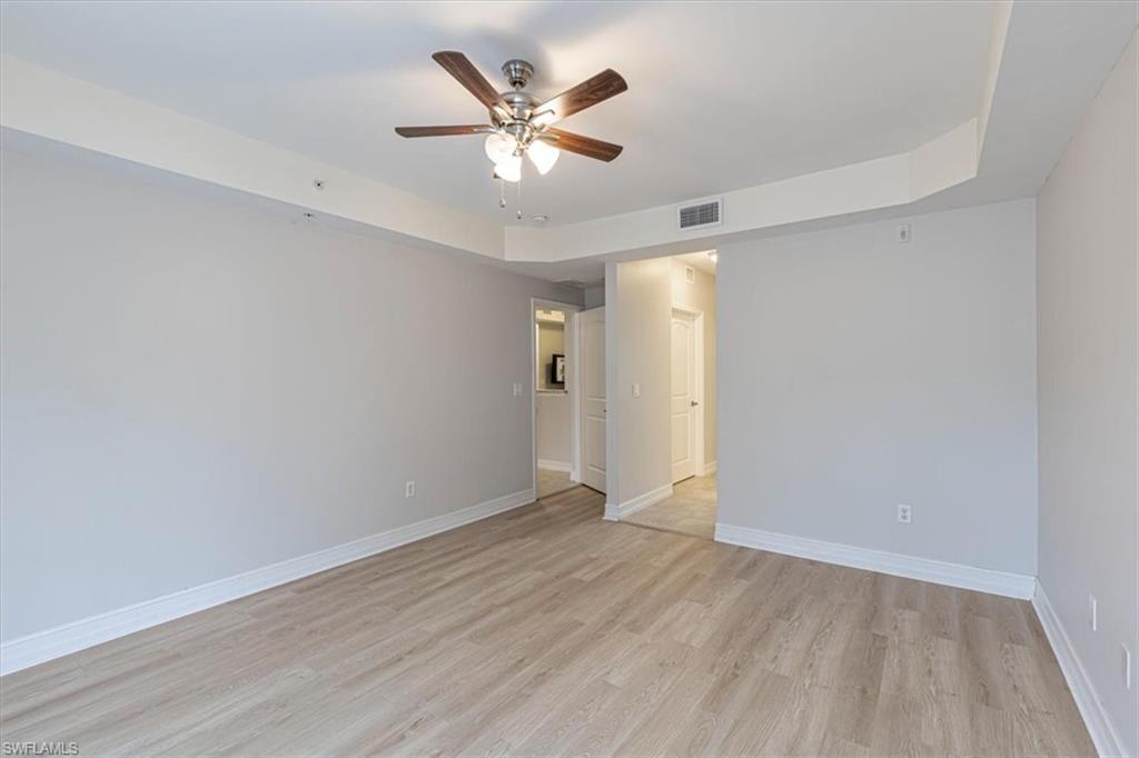1100 Pine Ridge Road Naples, FL 34108 - Photo 8 of 21 an empty room with wooden floor and ceiling fan