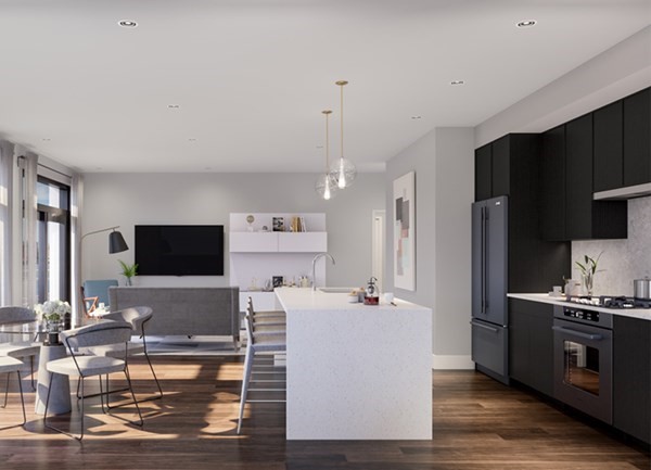 a living room with stainless steel appliances furniture and a flat screen tv