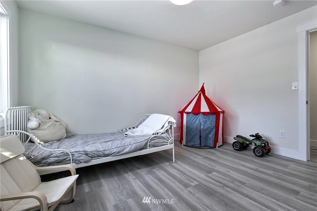 8925 Lake Steilacoom Point Road Southwest Lakewood, WA 98498 - Photo 23 of 31 a bedroom with a bed and wooden floor