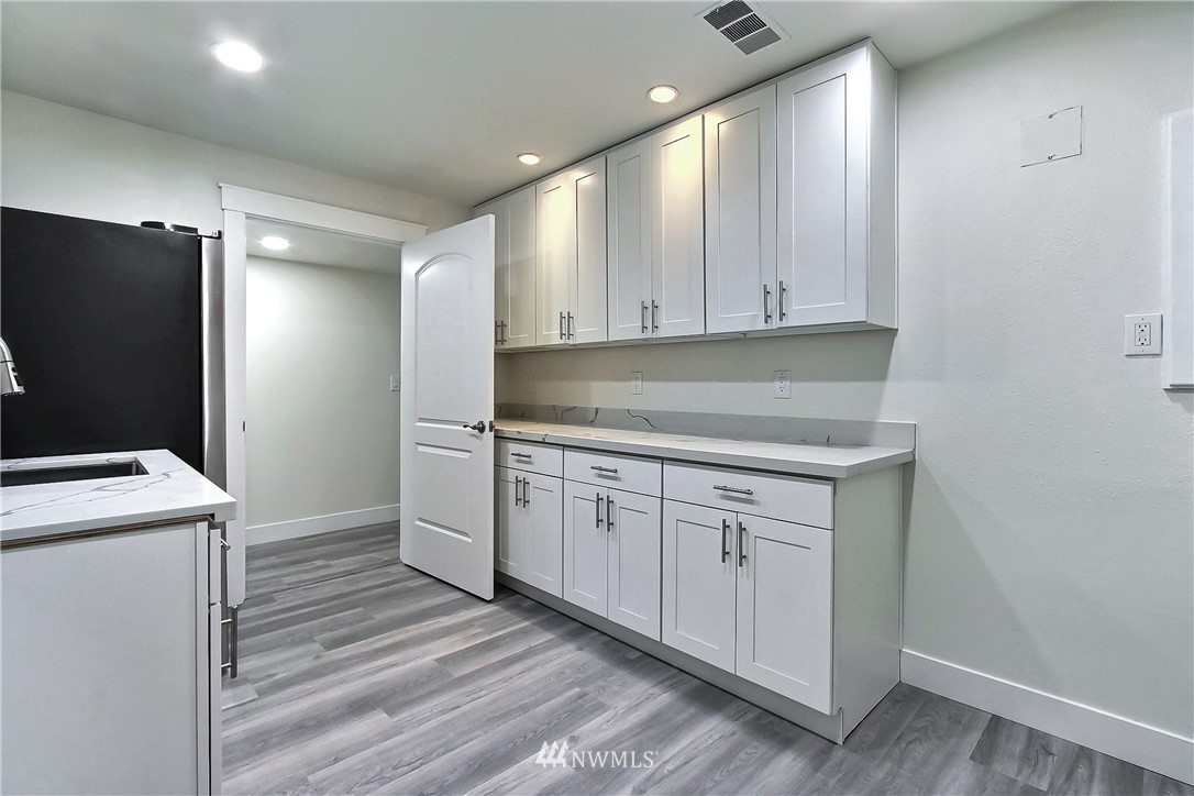 8925 Lake Steilacoom Point Road Southwest Lakewood, WA 98498 - Photo 27 of 31 a kitchen with white cabinets and white appliances
