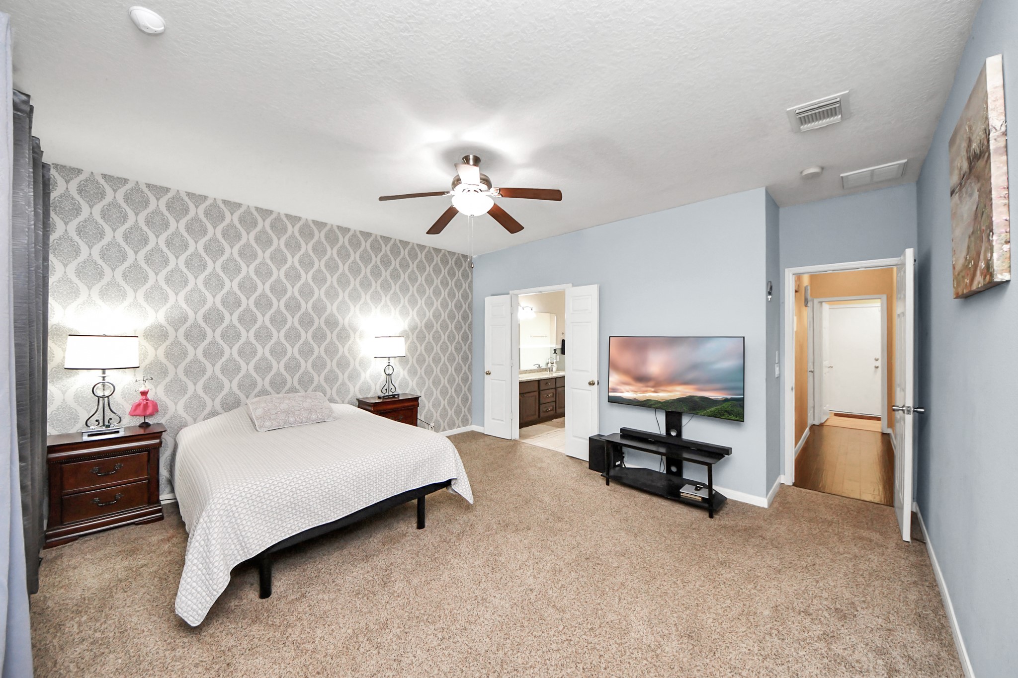 13635 Treebank Lane Houston, TX 77070 - Photo 14 of 37 a spacious bedroom with a bed and a chandelier
