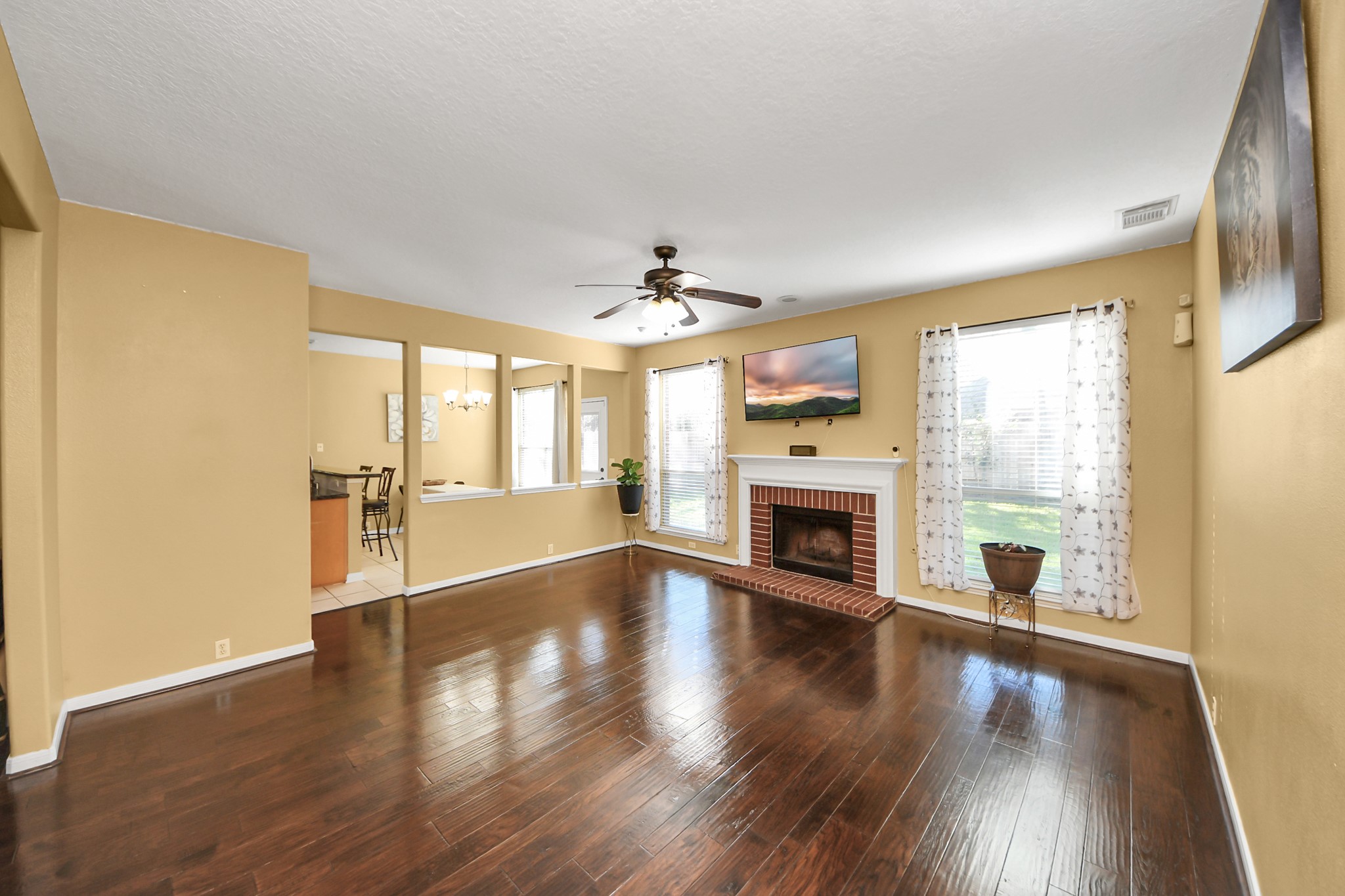 13635 Treebank Lane Houston, TX 77070 - Photo 4 of 37 a view of a big room with wooden floor fireplace and windows