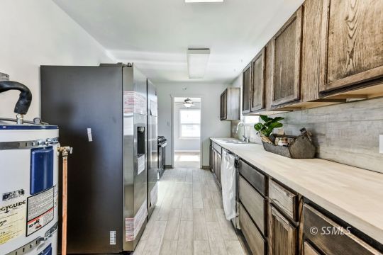 329 North Balsam Street Ridgecrest, CA 93555 - Photo 15 of 27 a kitchen with stainless steel appliances granite countertop a refrigerator a sink dishwasher a stove and white cabinets with wooden floor