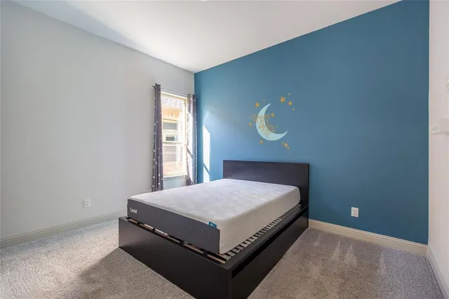 a bed sitting in a bedroom next to a window