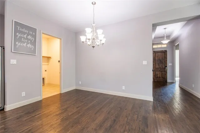 a view of a big room with wooden floor and windows