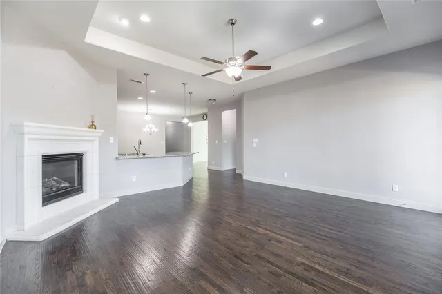 an empty room with wooden floor fireplace and windows