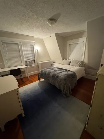 a bed sitting in a bedroom next to a window