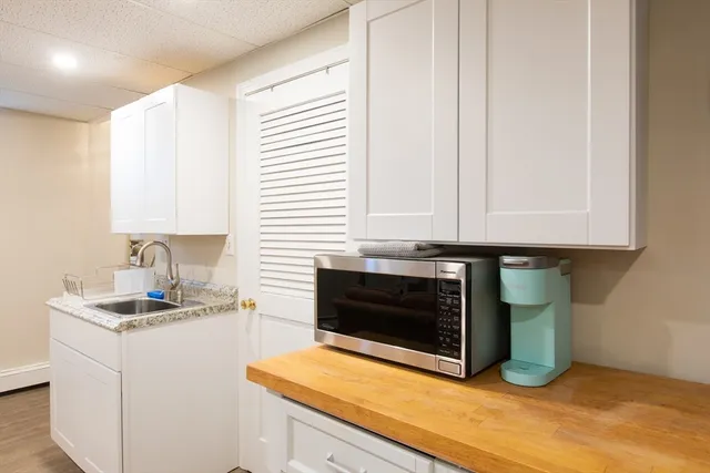 a kitchen with granite countertop white cabinets and white appliances