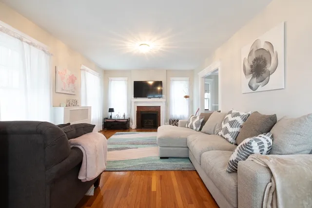 a living room with furniture a fireplace and a large window