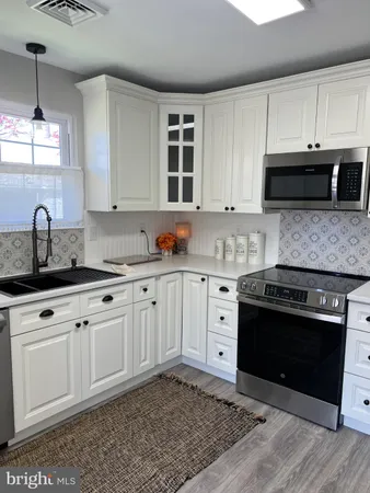 a kitchen with granite countertop a stove a sink and a microwave