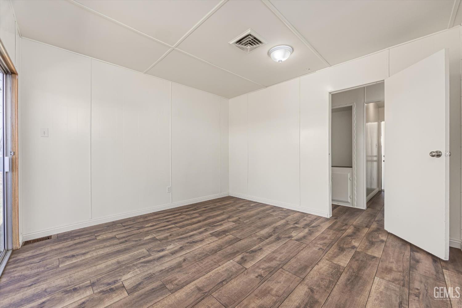 Undisclosed Address Bakersfield, CA 93306 - Photo 16 of 30 an empty room with wooden floor and closet