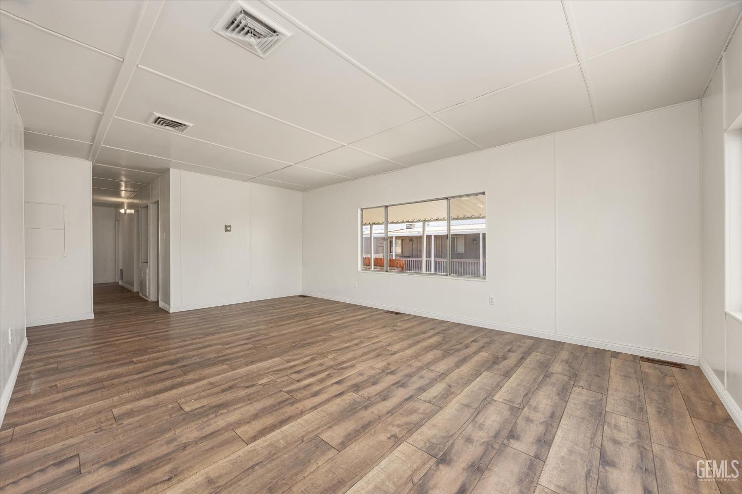 Undisclosed Address Bakersfield, CA 93306 - Photo 9 of 30 a view of an empty room with wooden floor and a window