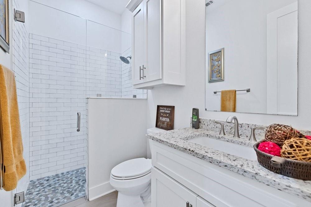 580 County Road 3422 Wills Point, TX 75169 - Photo 33 of 38 a bathroom with a granite countertop toilet sink and mirror