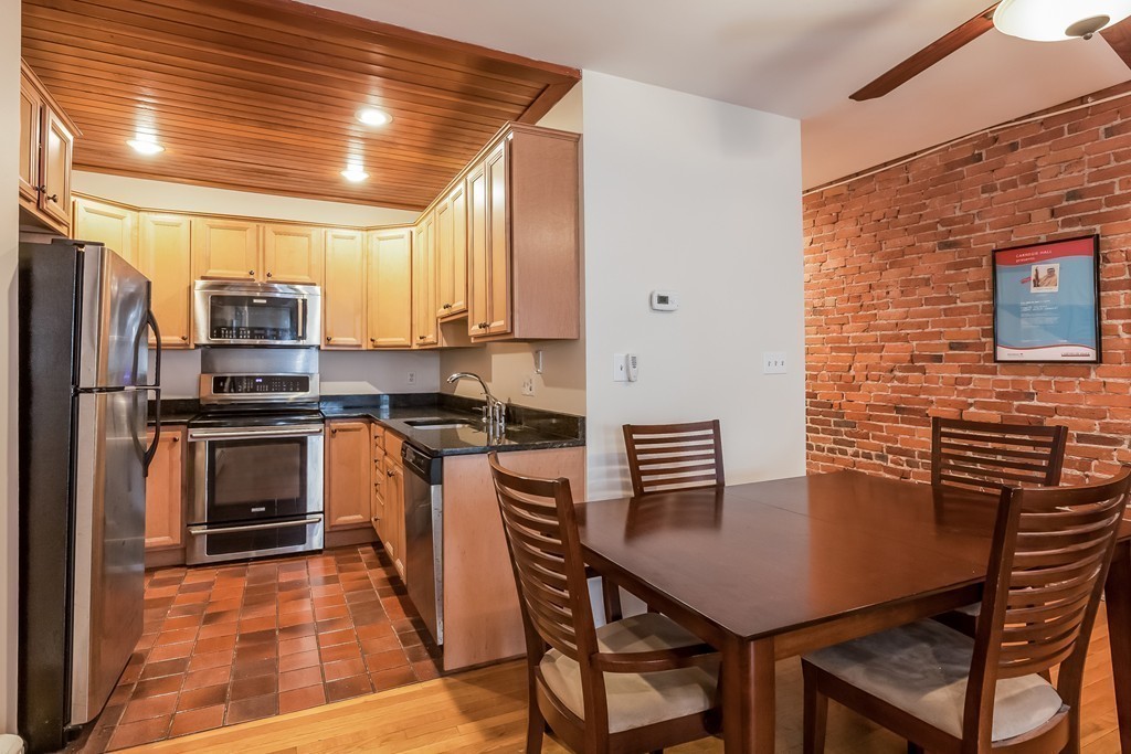 36 Symphony Road, Unit 3B Boston, MA 02115 - Photo 10 of 21 a kitchen with stainless steel appliances a stove a refrigerator a table and chairs