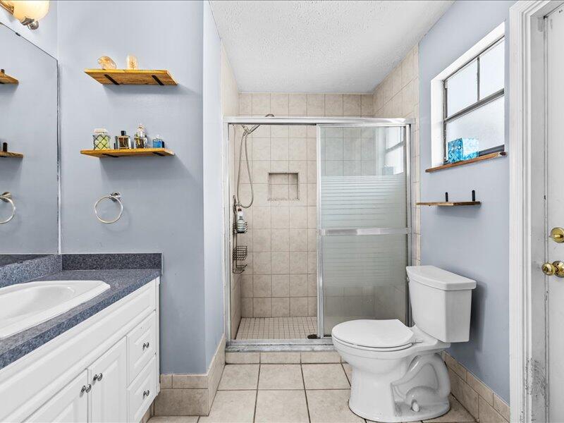 1297 Southeast Floresta Drive Port St. Lucie, FL 34983 - Photo 16 of 42 a bathroom with a sink toilet and shower