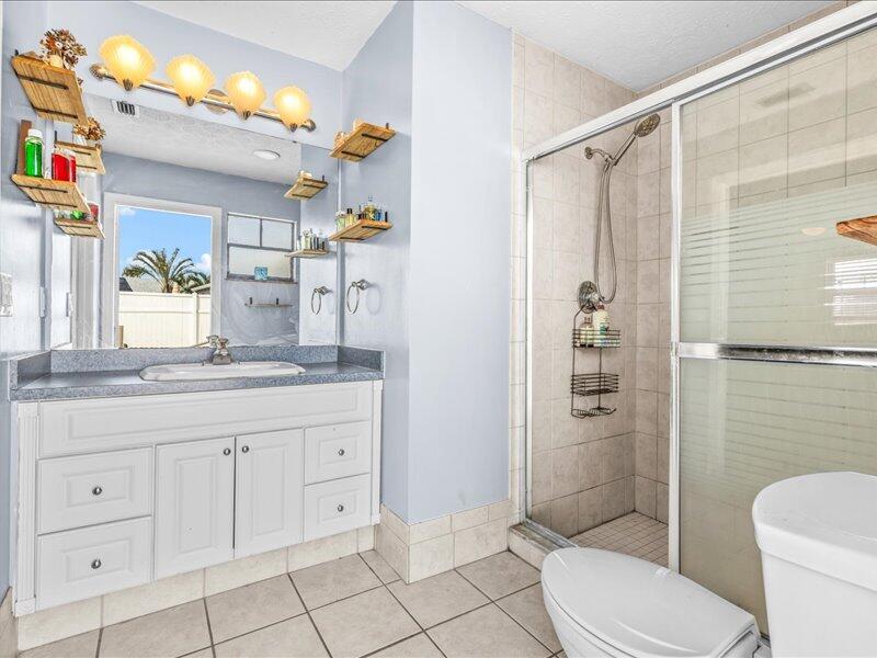 1297 Southeast Floresta Drive Port St. Lucie, FL 34983 - Photo 18 of 42 a bathroom with a granite countertop sink toilet and shower