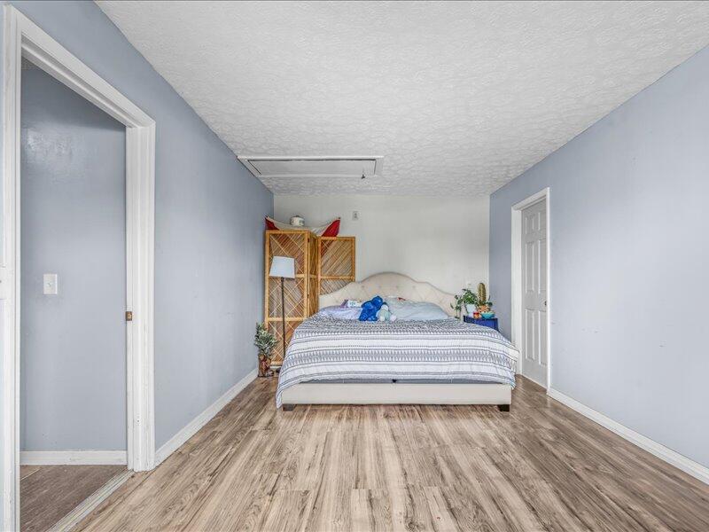 1297 Southeast Floresta Drive Port St. Lucie, FL 34983 - Photo 22 of 42 a bedroom with a bed and wooden floor