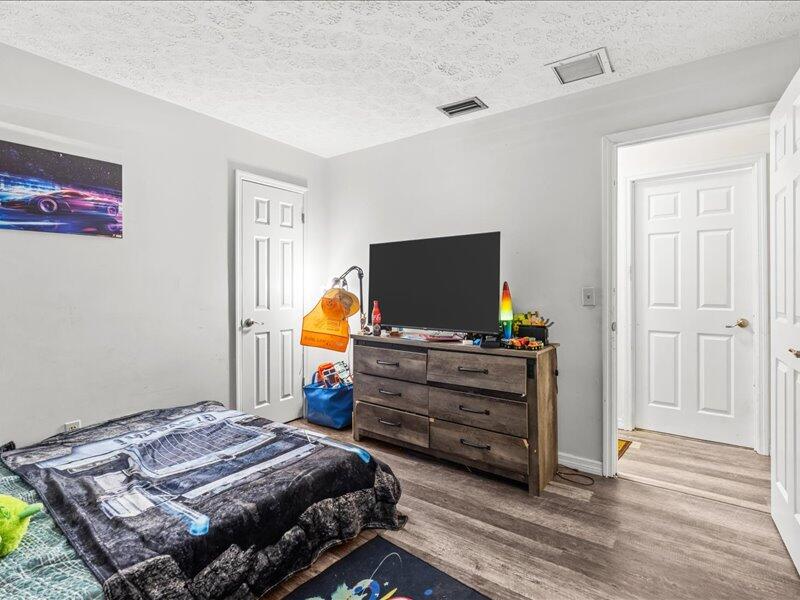 1297 Southeast Floresta Drive Port St. Lucie, FL 34983 - Photo 25 of 42 a bedroom with a bed and flat screen tv