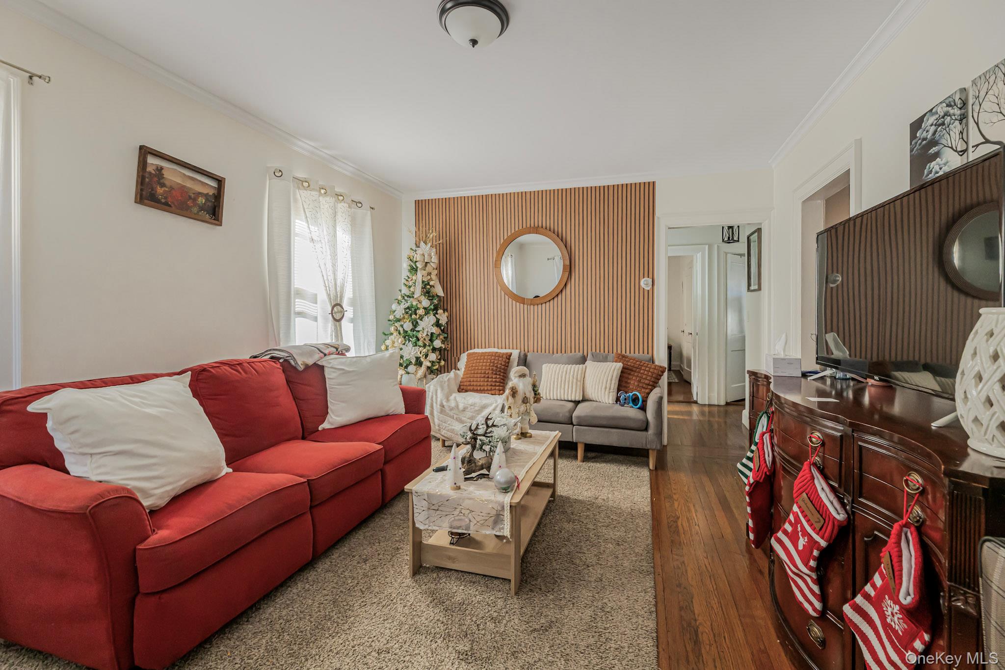 168 Stephenson Boulevard New Rochelle, NY 10801 - Photo 16 of 21 Living room with hardwood / wood-style flooring, ornamental molding, and an accent wall