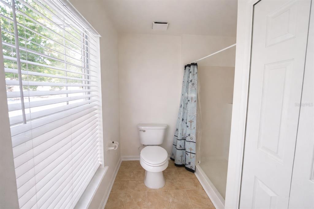 704 Swan Way Kissimmee, FL 34758 - Photo 10 of 15 a bathroom with a toilet and a shower