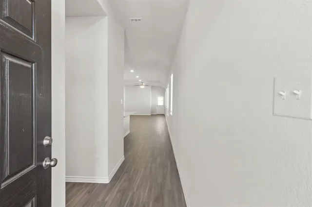 a view of a hallway with wooden floor