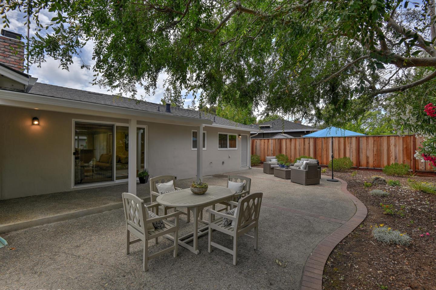 45 Stuart Court Los Altos, CA 94022 - Photo 8 of 10 a view of a backyard with table and chairs and wooden fence