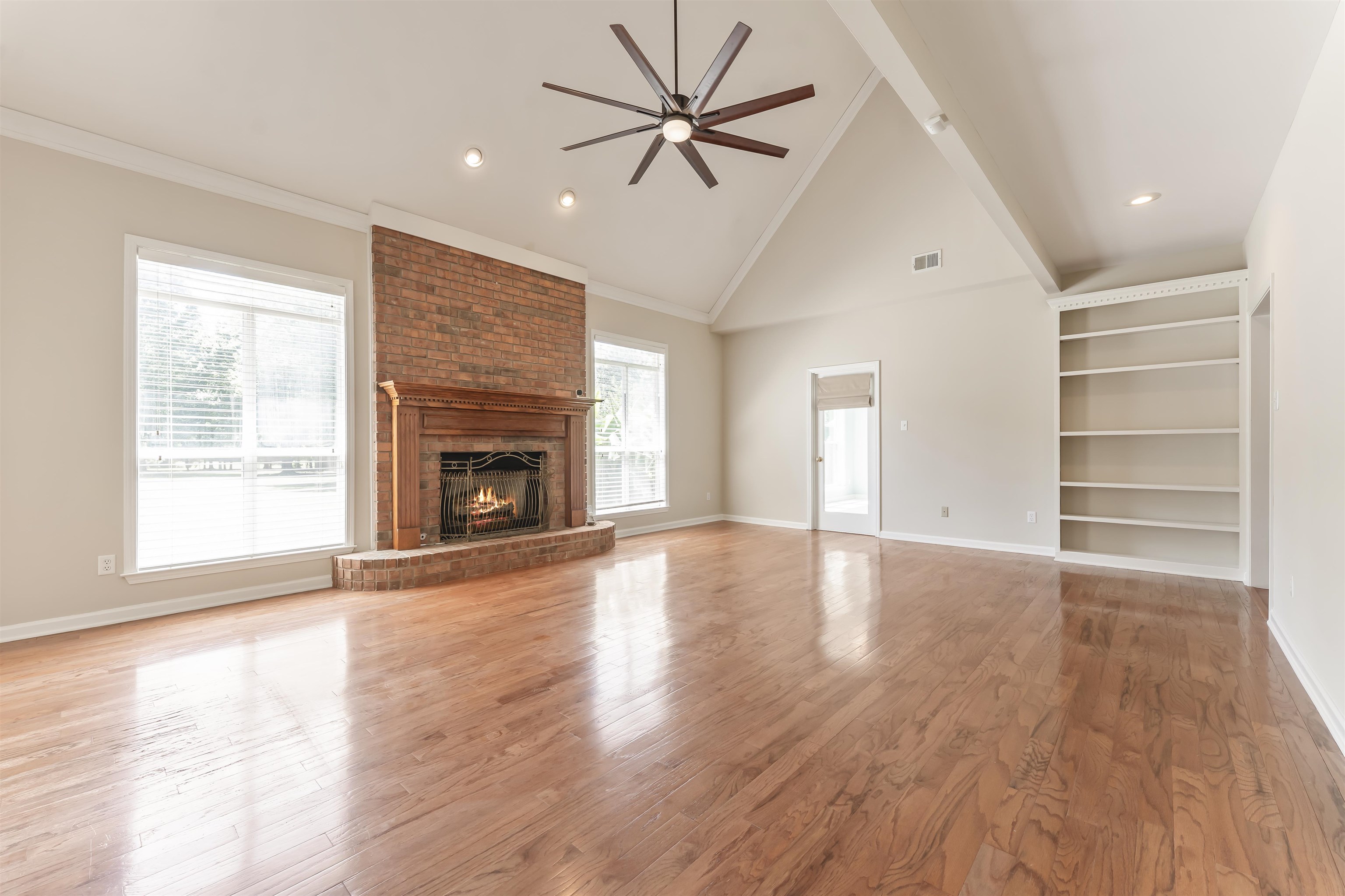 4279 High Plains Road Bartlett, TN 38135 - Photo 9 of 37 Spacious living area featuring high vaulted ceilings, wood-finish flooring, a brick fireplace with a wood mantle, and an integrated ceiling fan