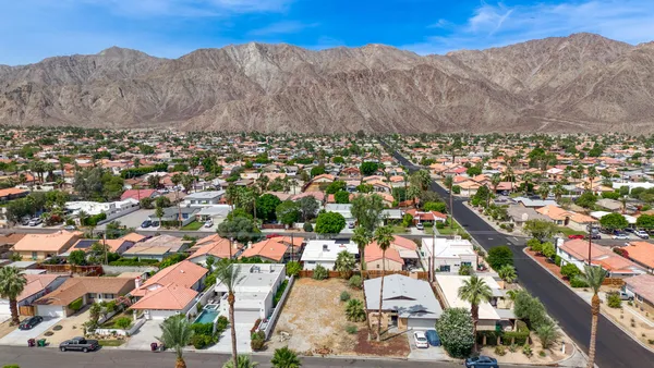 an aerial view of residential houses with outdoor space and trees