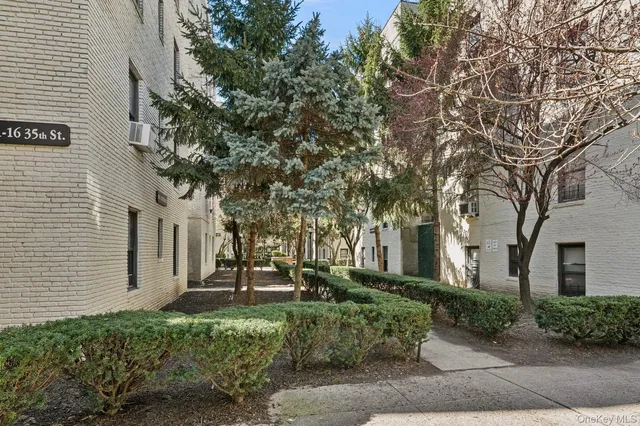 a front view of a house with a tree