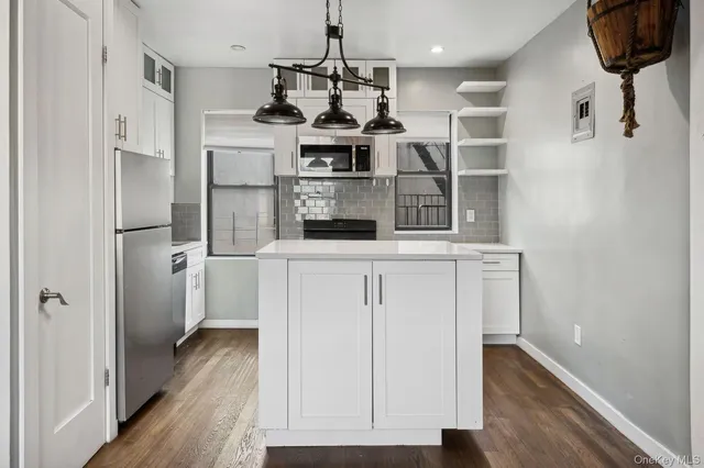 a kitchen with stainless steel appliances granite countertop a refrigerator and a stove top oven