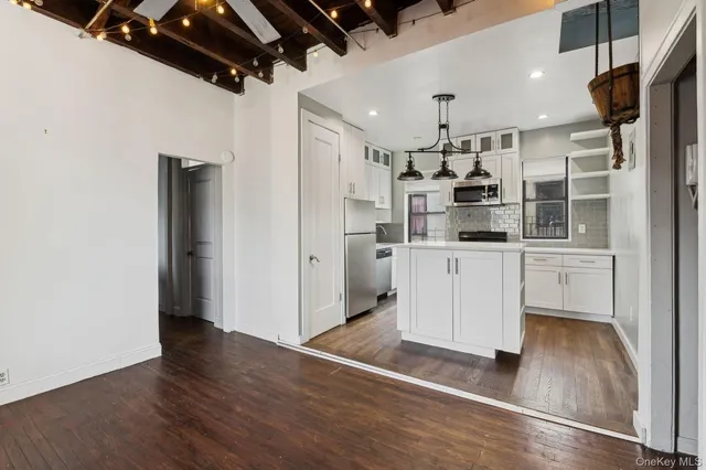 a kitchen with stainless steel appliances a refrigerator and wooden floor