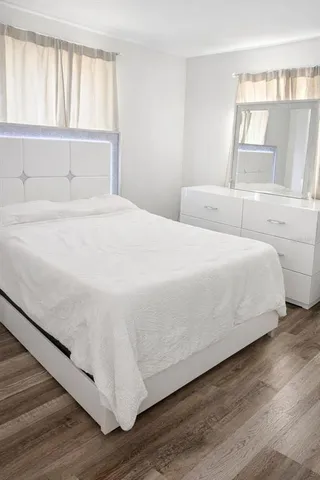 a bedroom with a bed and a large window